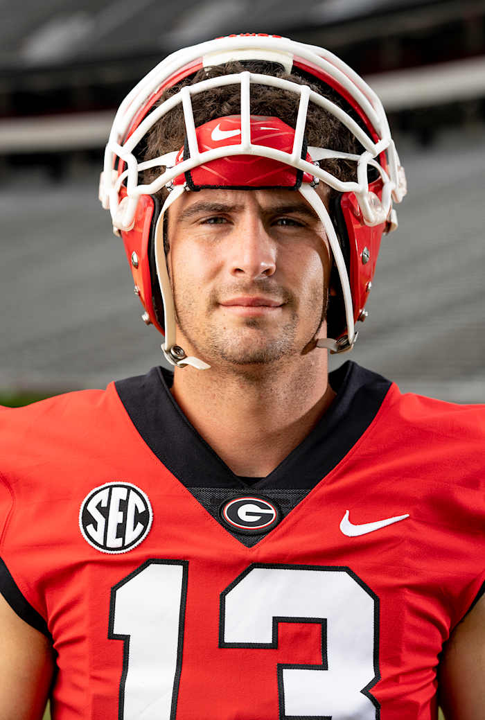 Stetson Bennett looks into camera with his helmet half on.